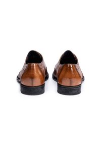 Braune Lederschuhe mit glatter Oberfläche, niedriger Ferse und abgerundeter Spitze. Schwarze Gummisohle. Rückansicht zeigt Details der Nähte.