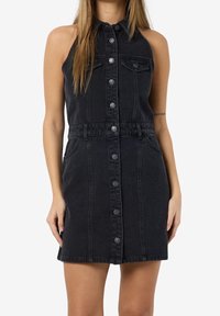 Černé džínové šaty s knoflíkovým zapínáním vpředu, bez rukávů, s límečkem, dvěma náprsními kapsami a облегченým pasem. Hladká textura, délka po kolena.