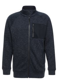 Giacca in pile blu scuro con zip completa, colletto alto, bottoni a scatto, polsini a coste e tasca sul petto con zip nera sul lato sinistro.