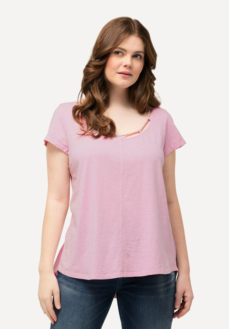 T-shirt rosa a maniche corte con scollatura a barca e cuciture a contrasto. Tessuto leggero con vestibilità rilassata. Abbinato a jeans blu scuro.