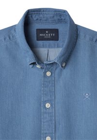 Camicia in denim azzurro chiaro con bottoni e colletto, dotata di bottoni bianchi e di un piccolo logo ricamato sul lato sinistro del petto.