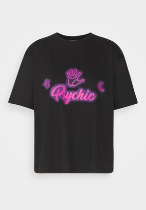 T-shirt noir à manches courtes avec texte rose néon « Psychic », une empreinte de paume dessinée, une étoile à gauche et un croissant de lune à droite.