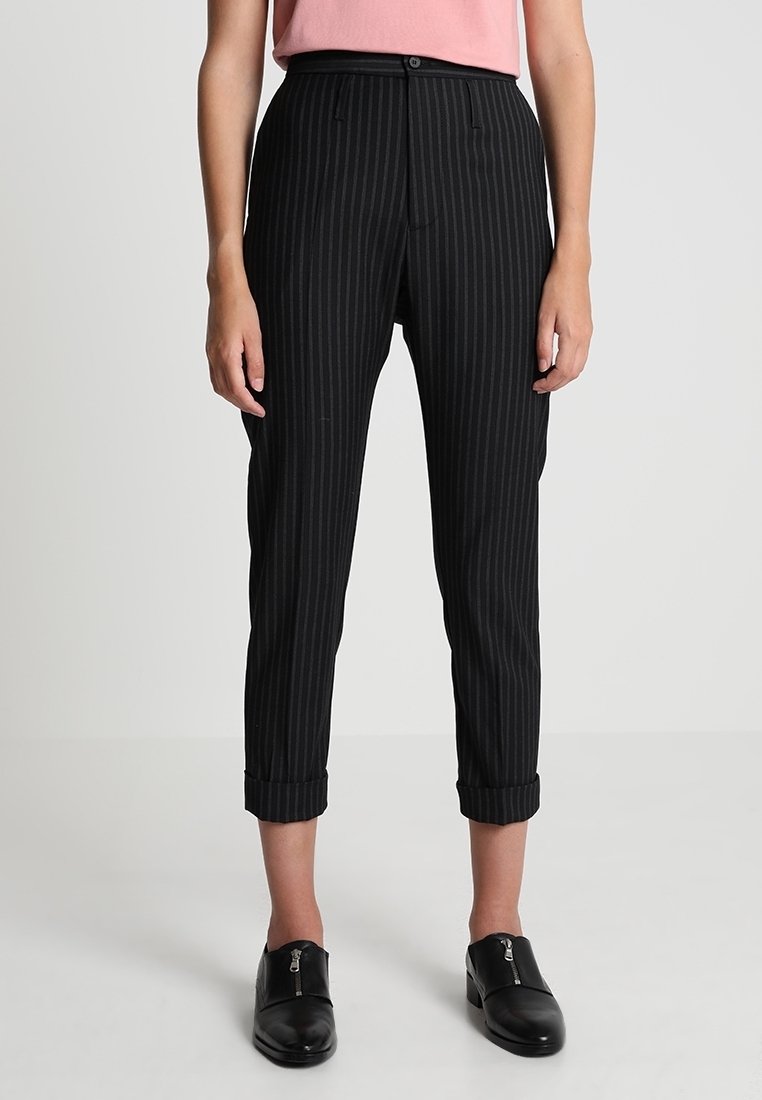 Svarta och grå randiga byxor med tapered ben, uppvikta fållar, knappstängning fram och bälteslänkar, tillverkade av ett mjukt och lätt tyg.