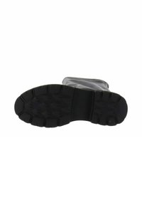 Suela de bota de goma negra con patrón de textura, que presenta profundos surcos para tracción y una zona central suave para flexibilidad.