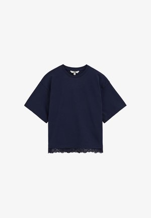 Camisa de manga corta azul marino con cuello redondo y ribete de encaje a lo largo del dobladillo inferior, mostrada sobre un fondo blanco liso.