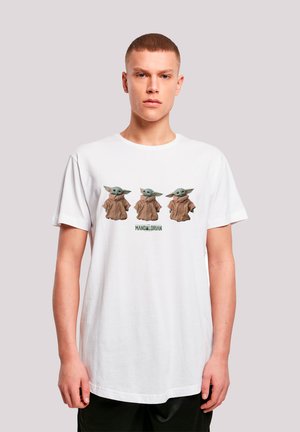Hvit bomull t-skjorte med tre tegneseriefigurer med store ører og brune kapper, tekst "MANDALORIAN" under figurene. Korte ermer, rund hals.