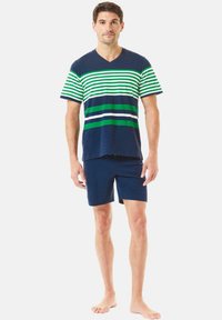 Camiseta de cuello en V azul marino con rayas horizontales verdes y blancas; combinada con pantalones cortos azul marino, de tela suave, liviana y con un ajuste casual.