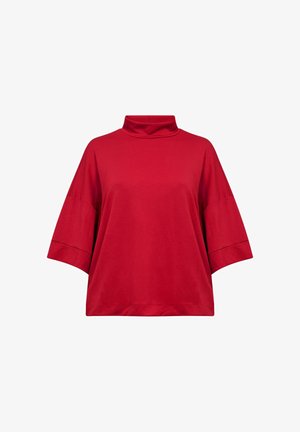 Punane puuvillane topp, millel on kõrge kaelus, lühikesed laiad varrukad ja lõdva istuvusega. Sile tekstuur, ilma mustrite või aktsendideta.