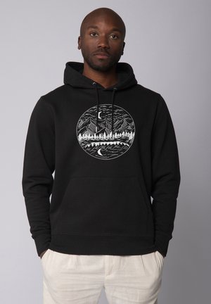 Zwarte hoodie van katoen, met een cirkelvormig grafisch ontwerp van bergen, bomen en een nachtelijke lucht. Inclusief een voorzak en een trekkoord.