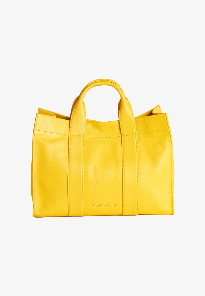 Gelbe Leder-Tote-Bag mit zwei oberen Tragegriffen, rechteckiger Form, glatter Textur, sichtbaren Nähten und prägtem Logo auf der Vorderseite.