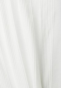 Vitt tyg med vertikal ribbad struktur, mjukt och lätt. Materialet har en svag glans som skapar ett jämnt, flödande utseende.