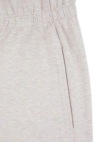 Ljusgråa sweatshirtbyxor med elastisk midja och sidoficka. Tillverkade av ett mjukt, strukturerat tyg med ett subtilt melerat mönster.