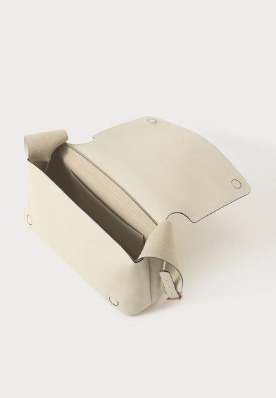 Borsa in pelle crema con un design strutturato, chiusura magnetica e texture morbida. Presenta una tasca interna per l'organizzazione e bordi arrotondati.