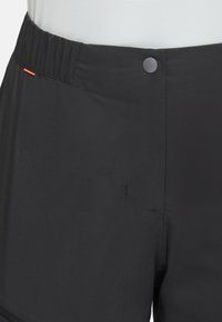 Svarta shorts med en текстurerad yta, med elasticitetsmidja, svart knappstängning och en orange dekorativ söm nära midjan.