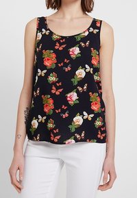 Top sin mangas negro con estampado floral de flores rojas y rosas, hojas verdes y mariposas naranjas. Tejido ligero con un corte relajado.