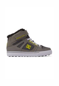 Zapatillas altas grises con un cuello de felpa, que incluyen una correa de velcro, acentos amarillos y una suela de goma blanca. Logo de DC mostrado en el lado.