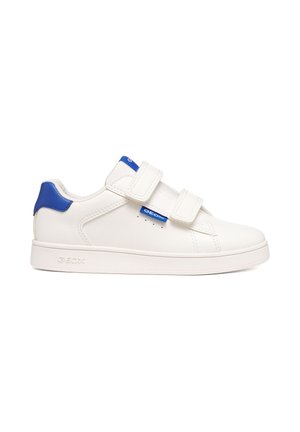 Sneaker bianca a bassa altezza con toppa blu sul tallone, due cinturini in velcro e targhetta blu con marchio sul lato, mostrata dal lato esterno.