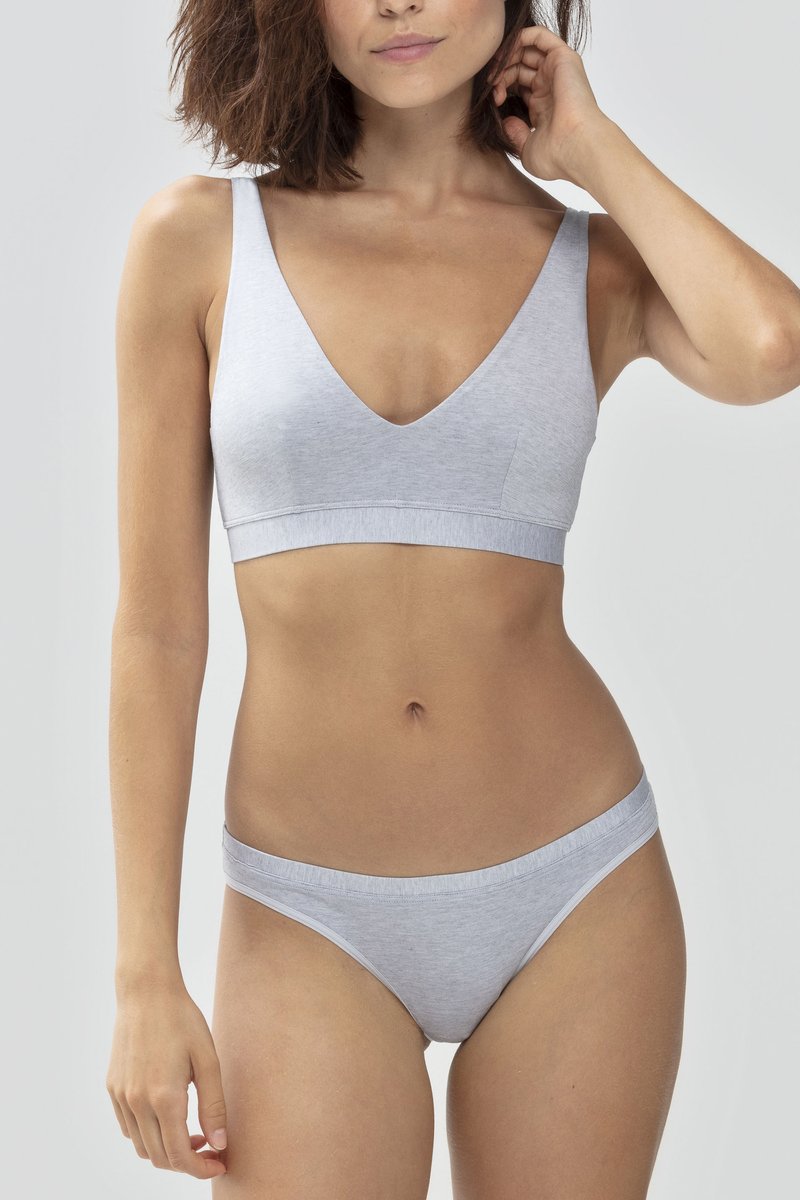 Bralette grigia chiara con scollatura a V profonda e spalline larghe, abbinata a culotte a vita bassa coordinate. Entrambi realizzati in tessuto morbido e liscio.