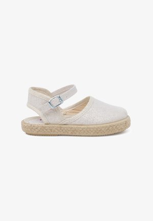 Espadrille de style ballet avec un dessus en tissu beige doux, une sangle de cheville avec boucle en argent et une semelle en jute tressé. Design léger et texturé.