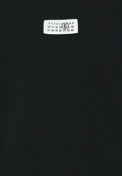 Tissu noir avec une étiquette rectangulaire blanche montrant les chiffres de 0 à 23 en trois rangées, le chiffre 6 est encerclé en noir.