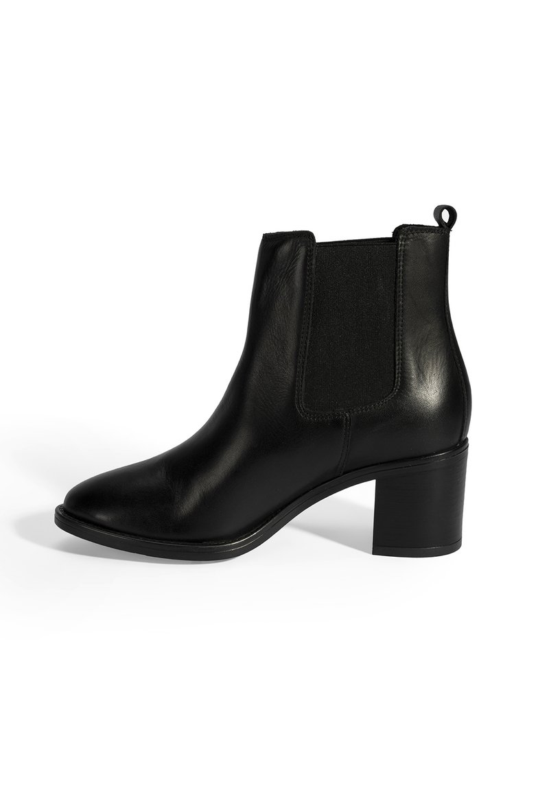 Bottines en cuir noir, avec des panneaux élastiques sur les côtés, bout pointu et talon bloc. Elles sont dotées d'une languette à l'arrière pour un enfilage facile.