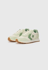 Grønne og kremfargede sneakers laget av semsket skinn og mesh-materialer, med en stjerne-logo, snørebånd design og gummisåle med et strukturert mønster.