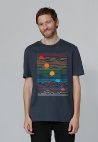 Navyblauwe katoenen t-shirt met een kleurrijke, horizontale lijnprint met bergen en zonmotieven in verschillende kleuren. Standaard pasvorm.