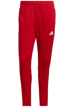 Pantalon de sport rouge fuselé avec une taille élastique et le logo Adidas blanc sur la partie supérieure de la cuisse droite.