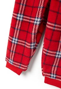 Mangas de chaqueta de forro polar rojo con un patrón a cuadros en blanco, azul marino y rosa, y puños acanalados rojos sobre un fondo blanco.