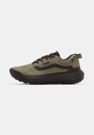 Zapatos deportivos color verde oliva con suela de goma negra, que cuentan con un upper de tela suave, cierre de cordones y una lengüeta trasera para facilitar el uso.