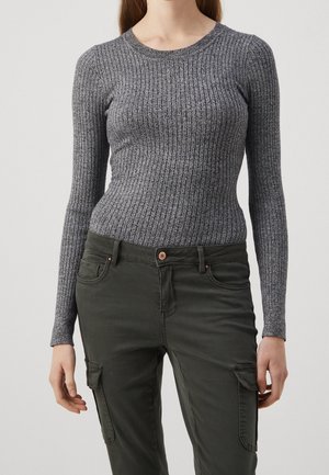 Top à manches longues côtelé en gris foncé, fabriqué à partir d'un tissu texturé. Associé à un pantalon cargo vert olive avec poches et fermeture à bouton.
