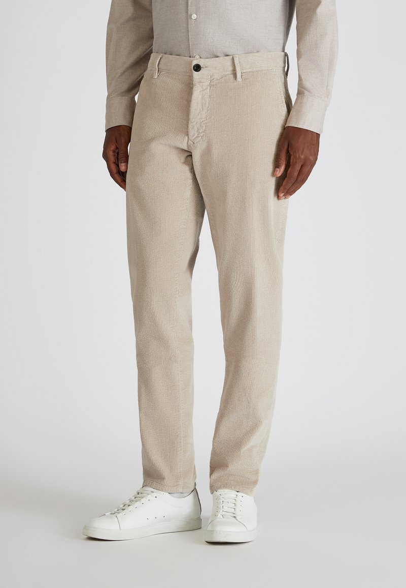 Beige corduroy broek met verticale strepen, zijzakken, een knoopsluiting en een rechte pasvorm, gecombineerd met witte sneakers.