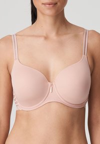 Różowy biustonosz z formowanymi miseczkami i regulowanymi ramiączkami. Posiada kształt w kształcie litery U z koronkowymi detalami po bokach i zapięciem na zamek z przodu.