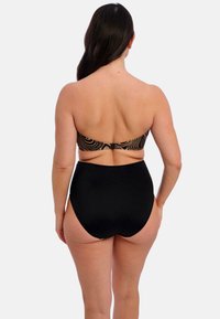 Parte inferior de bikini negra de cintura alta con un top bandeau estampado. El material parece suave con un ligero brillo. Detalle de cierre ajustable en la parte posterior.