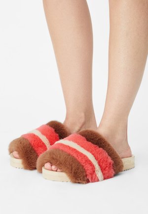 Sandales à glissière en fausse fourrure avec des rayures rouges, roses et crèmes, présentant une bande de fourrure marron et une semelle en bois clair avec un grip texturé.