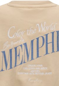 Felpa beige con grande scritta blu e bianca, che presenta frasi come "Colora il Mondo" e "MEMPHIS". Tessuto morbido al tatto, design a girocollo.