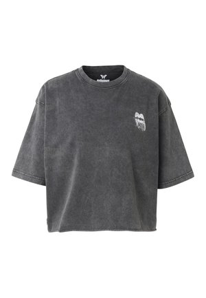 Tummanharmaa, lyhythihainen lyhyt t-paita, jossa vasemmassa rinnassa pieni valkoinen perhoskuvio ja pyöreä kaula-aukko.