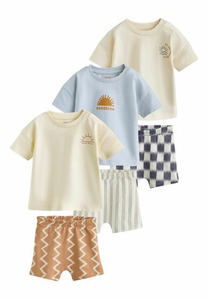 Tri detské súpravy s krátkymi rukávmi v krémovej a svetlomodrej farbe a zodpovedajúcimi vzorovanými šortkami so vzormi cik-cak, prúžkov a kockovanými.