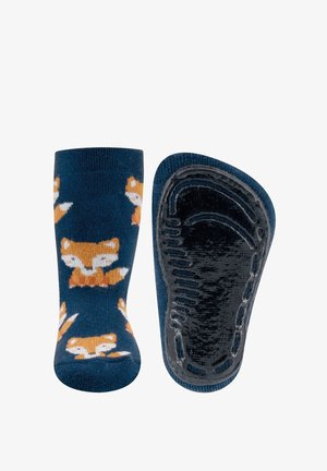 Marineblaue Socken mit orangefarbenen Fuchs-Mustern, ausgestattet mit einer strukturierten schwarzen Gummisohle für besseren Halt. Weiches Strickmaterial, eng anliegende Passform.