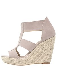 Sandalo wedge in suede beige con piattaforma in juta intrecciata, punta aperta, cinturini con ritaglio e chiusura con zip sul retro.