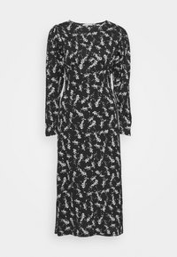 Robe noire à manches longues avec un motif floral blanc, encolure ronde, corsage ajusté et jupe fluide, fabriquée en tissu doux à la texture lisse.