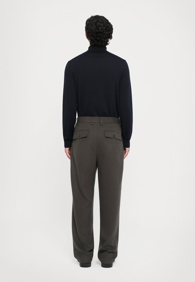 Jūras spēku krāsas turtlenecks ar olīvzaļiem platām biksēm. Biksēm ir aizmugurējās kabatas un tās ir izšūtas ar gludu apdari.