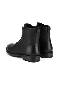 Melnas ādas potītes zābaki ar gludu tekstūru, apaļu purngalu, aukliņu priekšpusi un zemu salikto papēdi. Aizmugures rāvējslēdzēja detaļa ērtai uzvilkšanai.