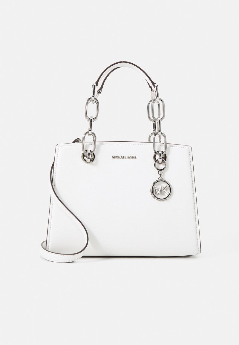 Sac à main blanc Michael Kors avec anses en chaîne argentée, breloque logo MK suspendue et bandoulière réglable.