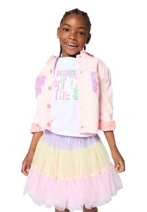 Veste en denim rose avec accents de sequins, T-shirt blanc avec texte coloré, et jupe en tulle multi-couches aux teintes pastel de rose, jaune et violet.