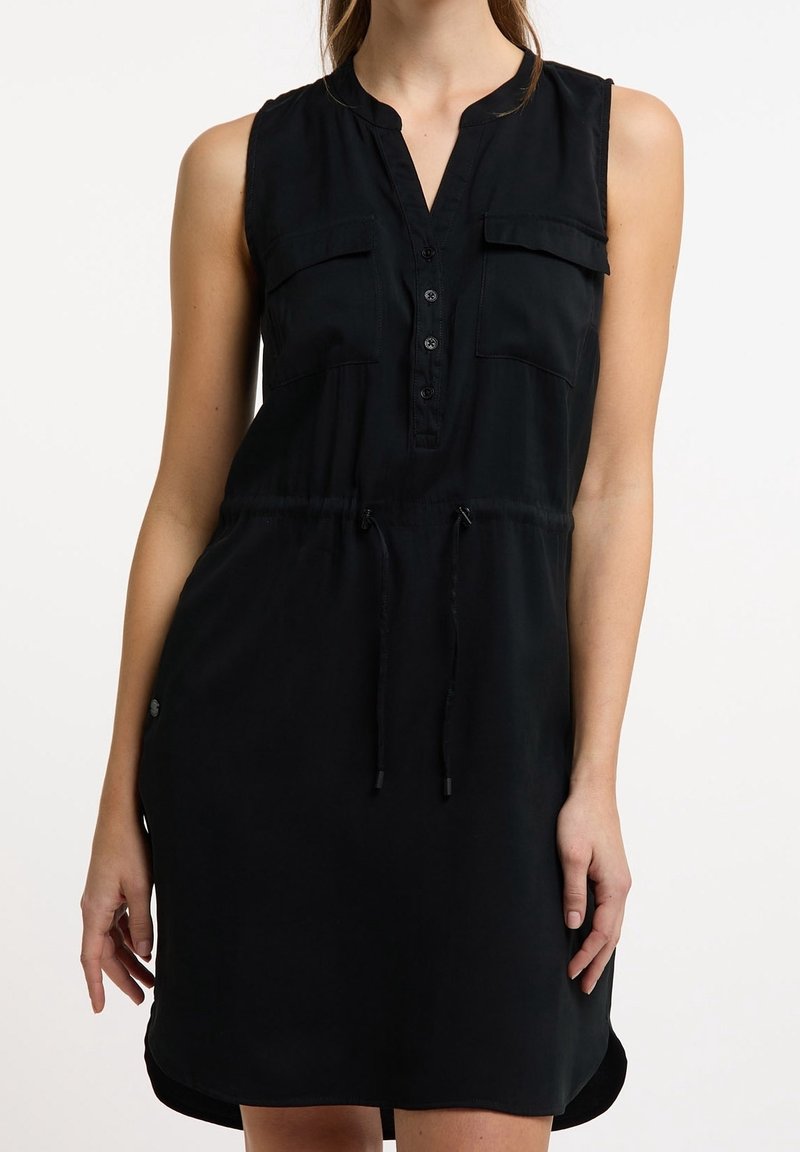 Vestido negro sin mangas con cuello tipo camisa, lista de botones, dos bolsillos en el pecho y cintura ajustable con cordón, presentando una textura suave.