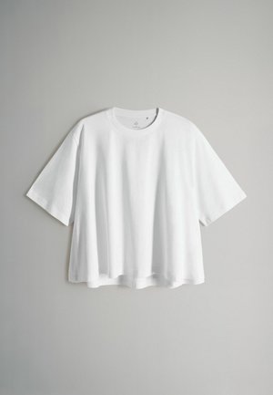 T-shirt bianca a maniche corte in cotone. Presenta una scollatura rotonda e una vestibilità rilassata e squadrata con un orlo leggermente curvo.