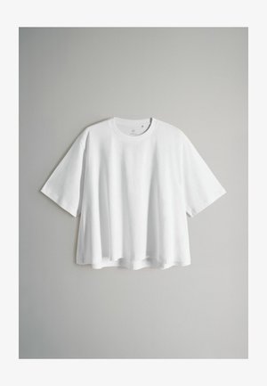 Weißes T-Shirt mit kurzen Ärmeln aus Baumwolle. Verfügt über einen runden Halsausschnitt und eine lockere, kastige Passform mit leicht geschwungenem Saum.