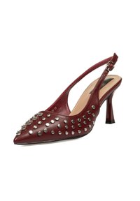 Zapato de tacón destalonado de cuero burdeos con punta afilada, adornado con tachuelas plateadas y un tacón de altura media con un acabado brillante.