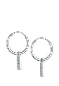 Silberne Ohrringe in Form von Ringen mit hängenden rechteckigen Anhängern, die mit "SELF" und "LOVE" graviert sind. Glänzende Metalloberfläche mit polierter Textur.